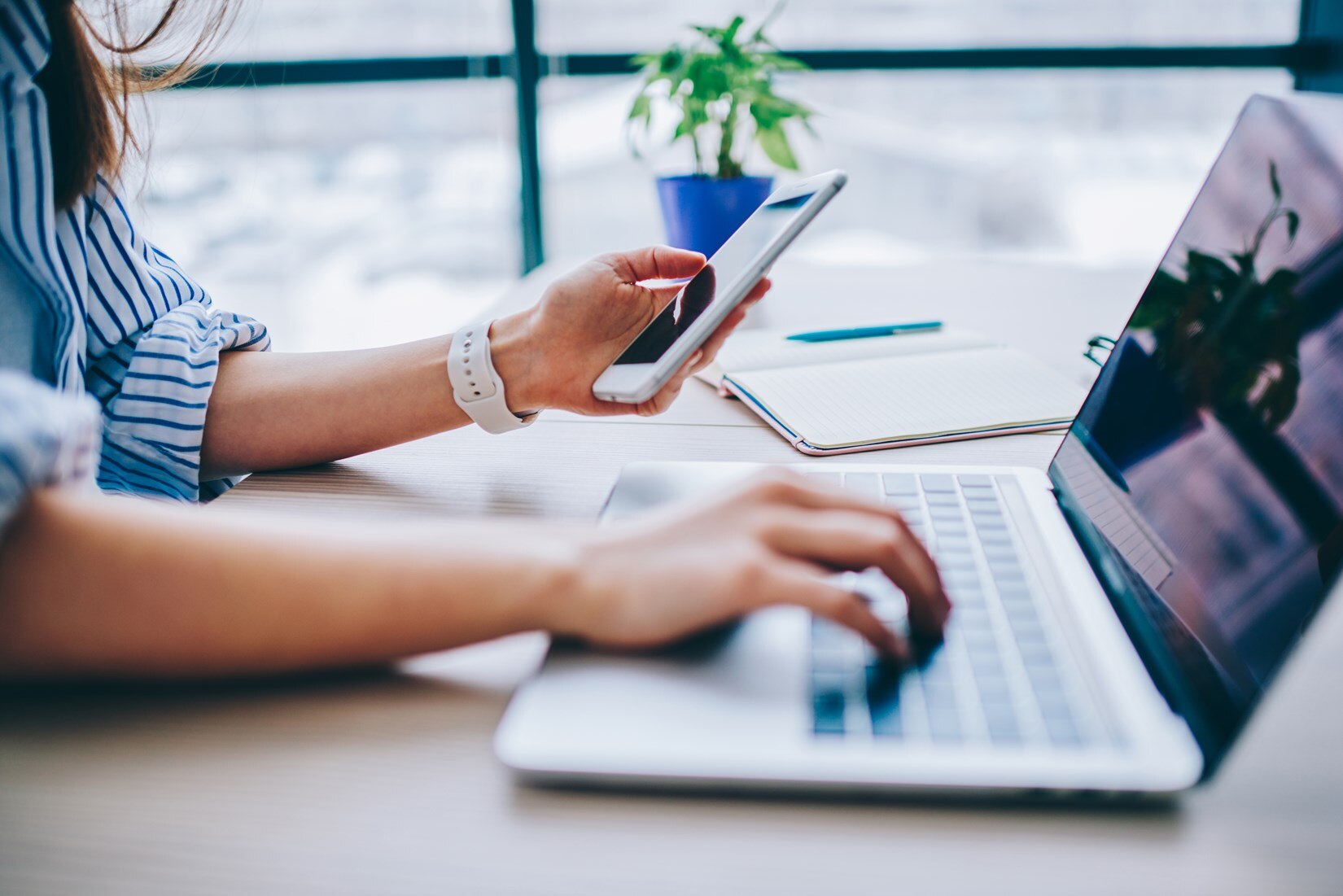 Woman using a phone and laptop at the same time.