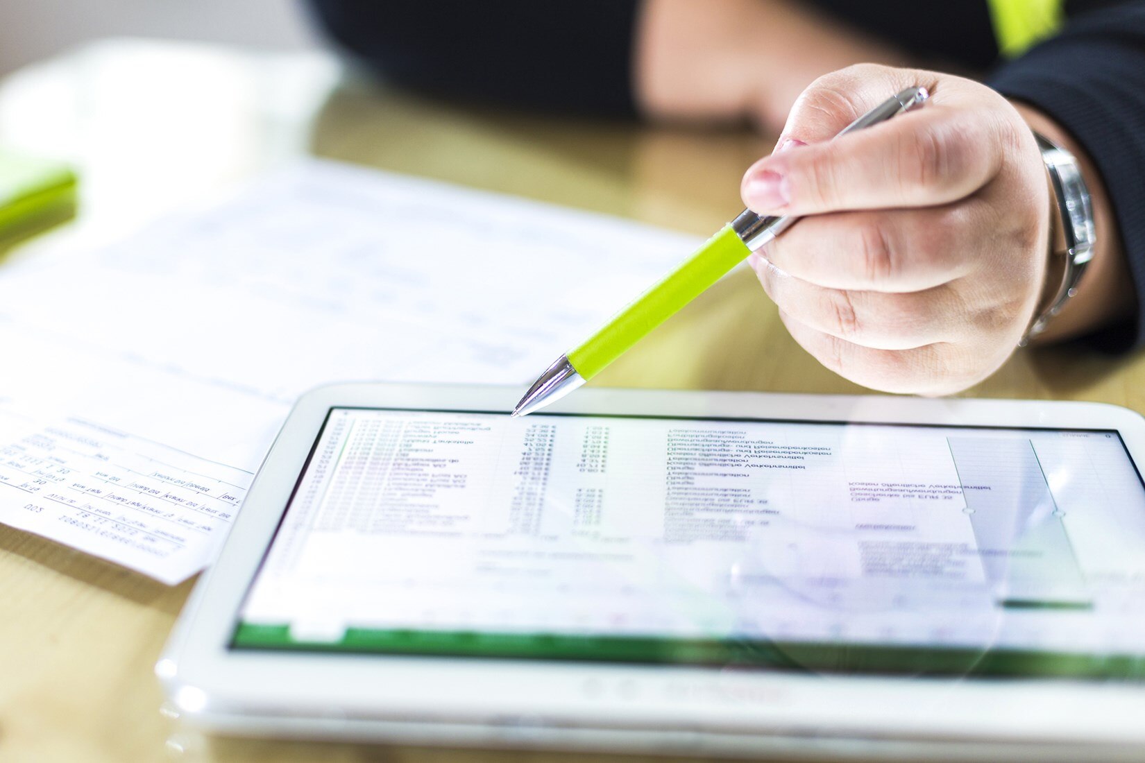 Person reviewing a cost spreadsheet on a tablet.