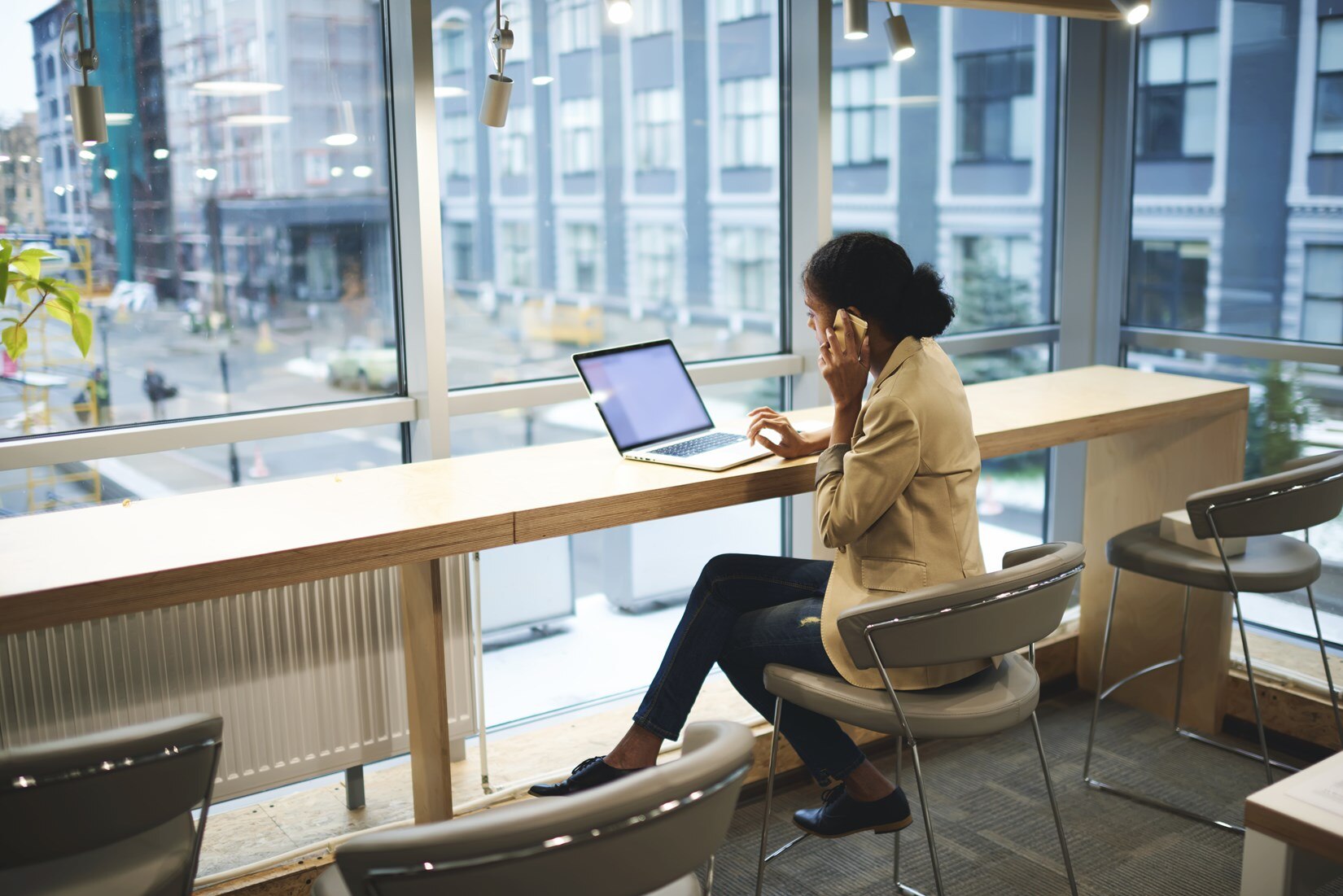 Woman on the phone while using a laptop.